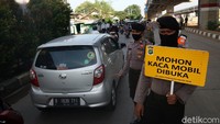 Pengendara mobil yang melintasi check point harus membuka kacanya untuk mempermudah petugas melakukan pemeriksaan.