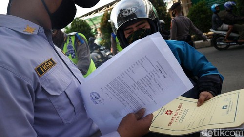 Petugas gabungan memeriksa warga yang memasuki wilayah DKI Jakarta di hari terakhir PSBB. Mereka memeriksa identitas hingga surat keterangan kerja kepada warga.