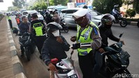 Petugas gabungan memeriksa surat-surat pengendara yang melintas di chect point PSBB, Kalimalang, Kamis (4/6/2020).