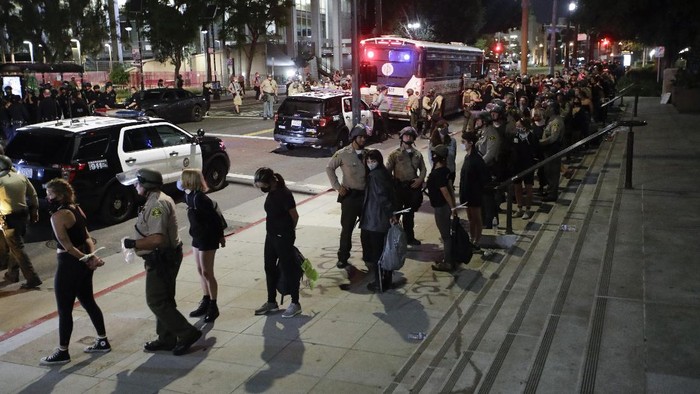 Demonstrators are arrested for a curfew violation Wednesday, June 3, 2020 in downtown Los Angeles during a protest over the death of George Floyd who died May 25 after he was restrained by Minneapolis police. (AP Photo/Marcio Jose Sanchez)