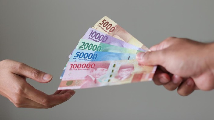 Memberikan uang man hand show rupiah money on white background