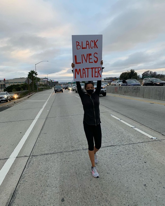 Penyanyi dan penulis lagu Tinashe turun ke jalan sambil membawa papan bertulisan BLACK LIVES MATTER. Show up, tulisnya di caption foto Instagram. Foto: Instagram/@tinashe
