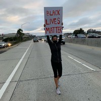 Penyanyi dan penulis lagu Tinashe turun ke jalan sambil membawa papan bertulisan BLACK LIVES MATTER. Show up, tulisnya di caption foto Instagram. Foto: Instagram/@tinashe