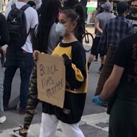 Ariana Grande dipuji netizen karena memanfaatkan nama besarnya untuk mengangkat isu rasisme dengan ikut demo Black Lives Matter untuk George Floyd. Mengenakan sweater oversized dan celana putih, ia juga membawa papan bertulisan Black Lives Matter. Foto: Twitter