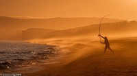 Lansekap dramatis ini diambil saat seorang nelayan di Pantai Chesil tengah memancing. Latar belakang matahari terbenam menambah keindahan.