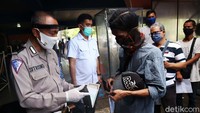 Petugas yang memeriksa berkas para pemohon memakai pelindung wajah.