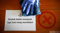 Tanda silang terpasang pada meja makan agar antar pengunjung berjarak.
