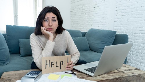 Portrait of worried young woman feeling stressed and desperate asking for help in paying bills, debts, tax expenses and accounting home finances with laptop. In online banking and financial problems.