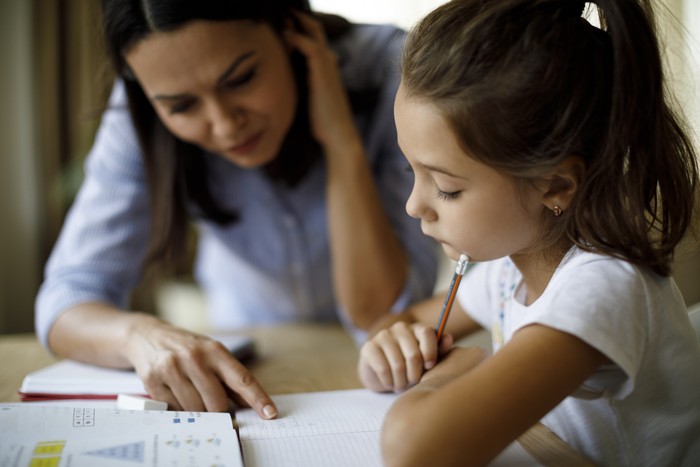 Anak belajar Mother helping daughter with homework