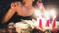 Cantiknya Gita saat makan malam merayakan pergantian tahun ditemani segelas wine dan lilin yang menambah kesan meriah. Foto: Instagram @gitasinaga