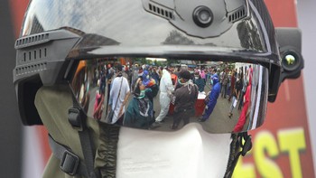 Petugas kesehatan di kawasan Surabaya, Jawa Timur, juga tampak mengenakan helm pendeteksi suhu tubuh saat penyelenggaraan rapid test massal pada Senin (1/6) lalu. ANTARA FOTO/Moch Asim.