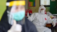 Salah seorang tenaga kesehatan beristirahat dengan mengenakan alat pelindung diri (APD) saat uji rapid test COVID-19 massal di Kota Pekanbaru, Riau. ANTARA FOTO/FB Anggoro
