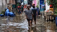 Meskipun air menggenangi pemukiman, warga tetap beraktivitas seperti biasa.