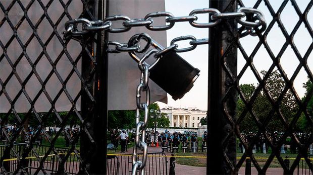 TOPSHOT - Police officers hold a perimeter behind the metal fence recently erected in front of the White House demonstrators gather to protest the killing of George Floyd on June 2, 2020 in Washington, DC. - Anti-racism protests have put several US cities under curfew to suppress rioting, following the death of George Floyd in police custody. (Photo by Olivier DOULIERY / AFP) (Photo by OLIVIER DOULIERY/AFP via Getty Images)