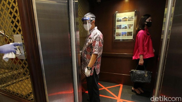 Karyawan hotel dan tamu tetap menjaga jarak sesuai protokol ksehatan.
