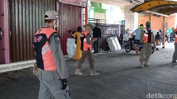 Personel Satpol PP menertibkan PKL di trotoar pasar Tanah Abang, Jakarta.