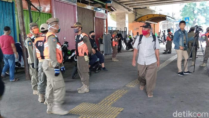 Personel Satpol PP menertibkan PKL di trotoar pasar Tanah Abang, Jakarta.