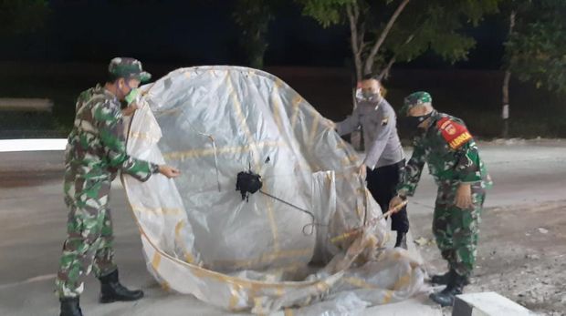 Petugas mengamankan balon udara yang jatuh di SPBU Kalijambe, Sragen, Jumat (5/6/2020).