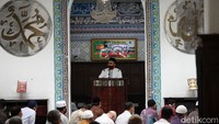 Khatib memberikan ceramah di hadapan jamaah salat Jumat. Dia berkhotbah dengan tetap memakai masker.