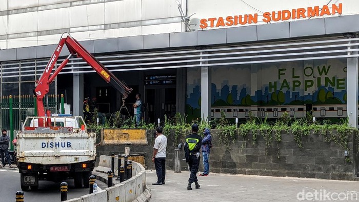 Depan Diberi Pembatas Beton ----   Petugas menurunkan road barrier beton, di depan akses Stasiun Sudirman, Jl Kendal, Jakarta, Jumat (5/6/2020).
