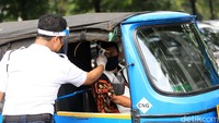 Sopir bajaj diukur suhu badannya saat akan masuk ke area masjid untuk melaksanakan salat Jumat.