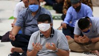 Seorang jemaah menutupi matanya dengan masker karena sengatan matahari.