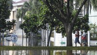 Warga melintas di Kompleks Pantai Mutiara yang tergenang banjir rob di Penjaringan, Jakarta.