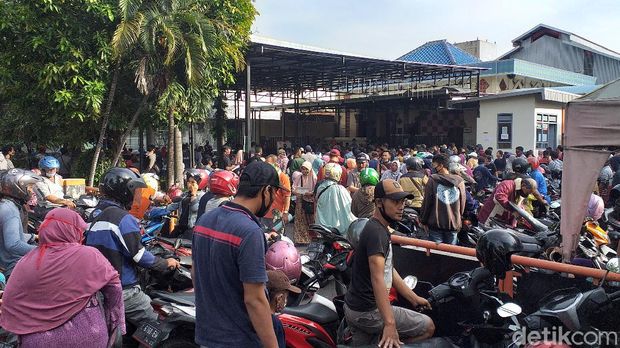Ratusan warga berdesak-desakan saat antre mengambil dana bantuan sosial tunai (BST) Rp 600 ribu di Kantor Pos Jemur Andayani. Kondisi ini mengkhawatirkan sebab mengabaikan aturan physical distancing di tengah pandemi COVID-19.