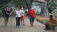 Sejumlah warga yang berolahraga di kawasan Kanal Banjir Timur pun tampak mengenakan masker untuk mencegah penyebaran COVID-19.