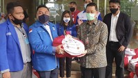 Ketua Majelis Pertimbangan Organisasi (MPO) Gerakan Angkatan Muda Kristen Indonesia (GAMKI) Michael Wattimena (ketiga kiri) bersama pengurus GAMKI menerima bantuan sembako dari Presiden RI melalui Menteri Sosial Juliari P Batubara (ketiga kanan) di Graha Oikumene, Jakarta, Minggu (7/6/2020). Foto: Istimewa.