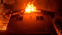 Penampakan api yang melalap sebuah bangunan di area dekat Winters, California, AS, pada Minggu (7/6/2020) waktu setempat.