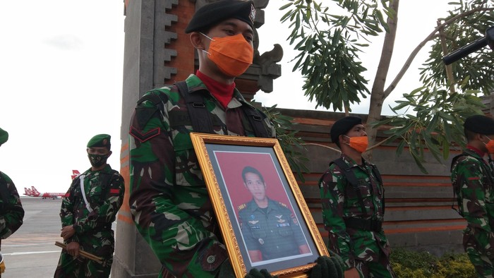Prajurit TNI memegang foto mendiang Kapten Cpn I Kadek Udi Suardiasa. (Angga Riza/detikcom)