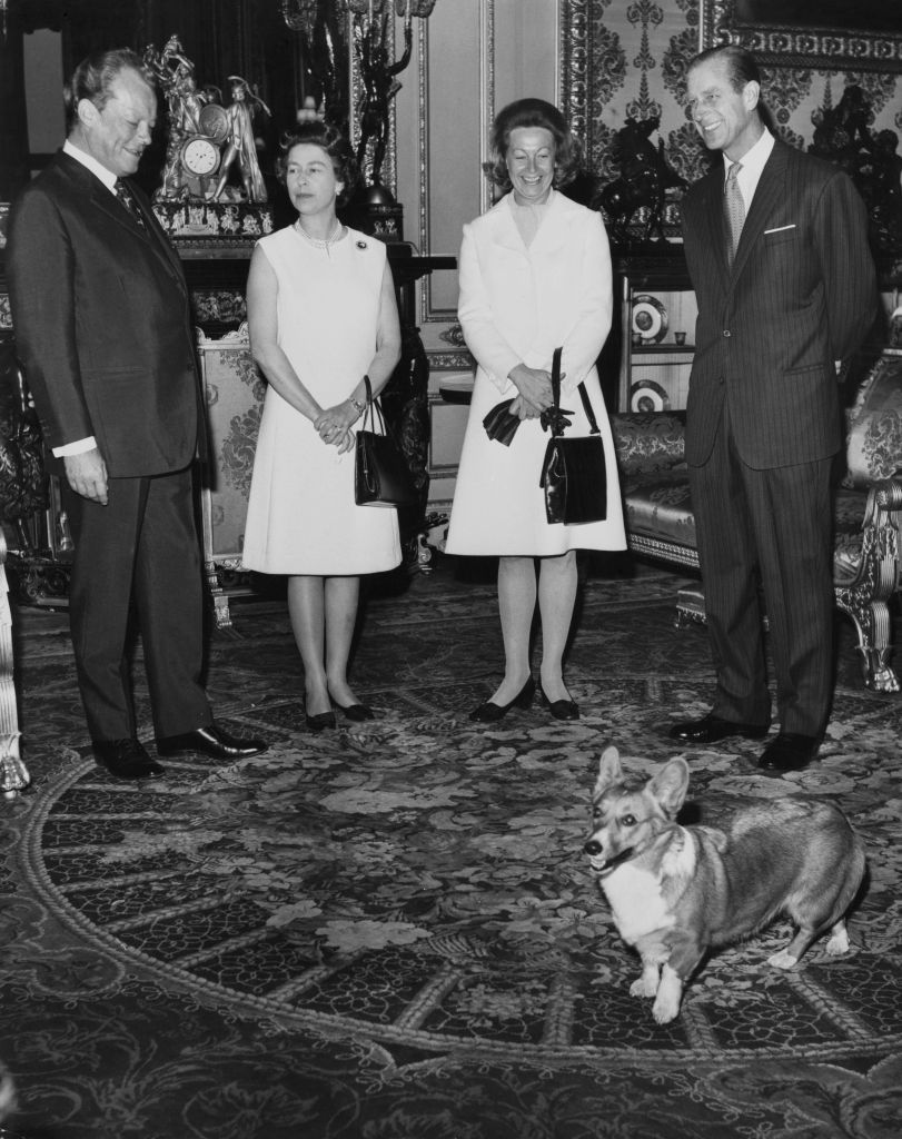 From left to right, West German Chancellor Willy Brandt (1913 - 1992), Queen Elizabeth II, Brandt's wife Rut, and the Duke of Edinburgh at Windsor Castle during the Brandts' visit to England, 20th April 1972. They are amused by the antics of one of the royal corgis.  (Photo by Douglas Miller/Keystone/Hulton Archive/Getty Images)