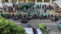 Puluhan ojek online parkir di bahu jalan menambah macet jalan di depan Stasiun Palmerah seiring pemberlakuan new normal transisi.