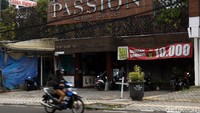Seorang pengendara motor melintas di samping factory outlet yang tampak sepi dari pengunjung di kawasan Bandung, Jawa Barat, Senin (8/6/2020).