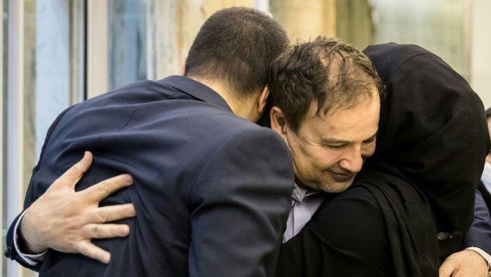 Ilmuwan Iran, Majid Taheri berpelukkan dengan anak-anaknya di bandara  Imam Khomeini International Airport usai dibebaskan oleh AS (AFP)