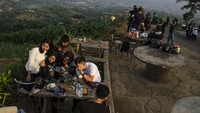 Pengunjung menikmati suasana pemandangan di salah satu saung kawasan wisata Caringin Tilu, Kabupaten Bandung Jawa Barat, Minggu (7/6/2020). Kawasan Wisata perbukitan Cartil kembali dibuka dengan kenormalan baru karena tidak termasuk dalam PSBB Parsial di Kabupaten Bandung. (ANTARA FOTO/NOVRIAN ARBI)