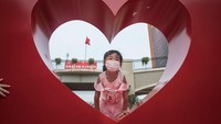 Seorang anak terlihat bermain di sekitar patung berbentuk hati di Wuhan, Hubei, China.