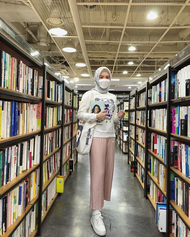 Bergaya di sebuah perpustakaan di Korea, Ayana tampil casual saat melakukan foto #ootd. Ayana terlihat memakai masker putih polos yang senada dengan sweater dan sneakersnya. Foto: instagram @xolovelyayana.