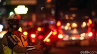 Seorang petugas tengah mengatur lalu lintas di ruas jalan yang tampak macet di salah satu kawasan Ibu Kota.