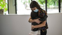 Seorang siswa memeluk gurunya di hari pertama kembali bersekolah di kawasan Barcelona, Spanyol.
