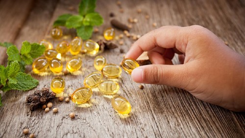 young girl being given childrens supplements or vitamin by her mother