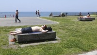 Sejumlah warga tengah berjemur di Pantai Katase-kaigan yang berada di Fujisawa, Prefektur Kanagawa, Jepang.