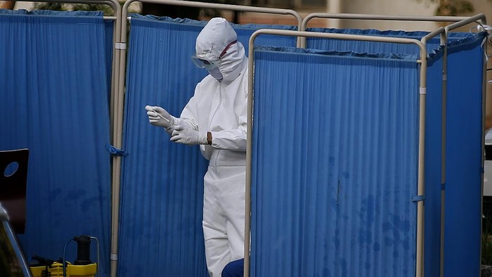 A health worker collects a sample from a man at a drive-through testing and screening facility for the coronavirus, in Islamabad, Pakistan, Saturday, June 6, 2020. (AP Photo/Anjum Naveed)