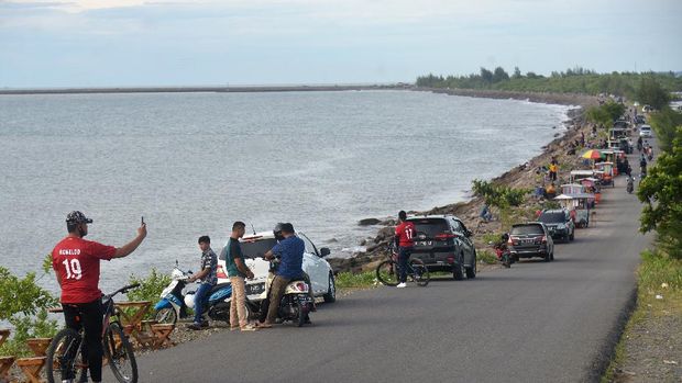 Pengunjung menikmati suasana di kawasan wisata pantai  Ulee Lheue dan Kampung Jawa, Banda Aceh, Aceh, Minggu (7/6/2020). Sejumlah objek wisata pantai di daerah tersebut  kembali ramai pengunjung dan pedagang kuliner keliling, yang sebagian besar tidak menerapkan protokol kesehatan untuk mencegah penyebaran COVID-19. ANTARA FOTO/Ampelsa/aww..