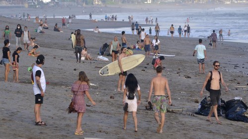 Wisatawan memadati kawasan Pantai Canggu, Badung, Bali, Kamis (4/6/2020). Warga dan wisatawan dari berbagai negara terpantau mengunjungi objek wisata yang sebenarnya masih ditutup dari kunjungan wisatawan sebagai upaya untuk mencegah penyebaran COVID-19 tersebut dengan melewati akses-akses masuk pantai yang tidak dijaga oleh petugas. ANTARA FOTO/Fikri Yusuf/aww.