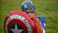 Seorang pendemo yang mengenakan kostum Captain America menghadiri demonstrasi Black Lives Matter di Holyrood Park, Edinburgh, Inggris.