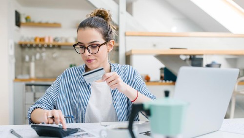Young woman paying bills/ shopping online with credit card