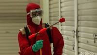 Petugas tampak mengenakan pakaian pelindung diri mulai dari masker, kacamata hingga sarung tangan saat bertugas menyemprotkan cairan disinfektan di area Pasar Senen.
