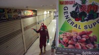 Penampakan sejumlah toko yang tutup saat petugas sedang menyemprotkan cairan disinfektan di area Pasar Senen.